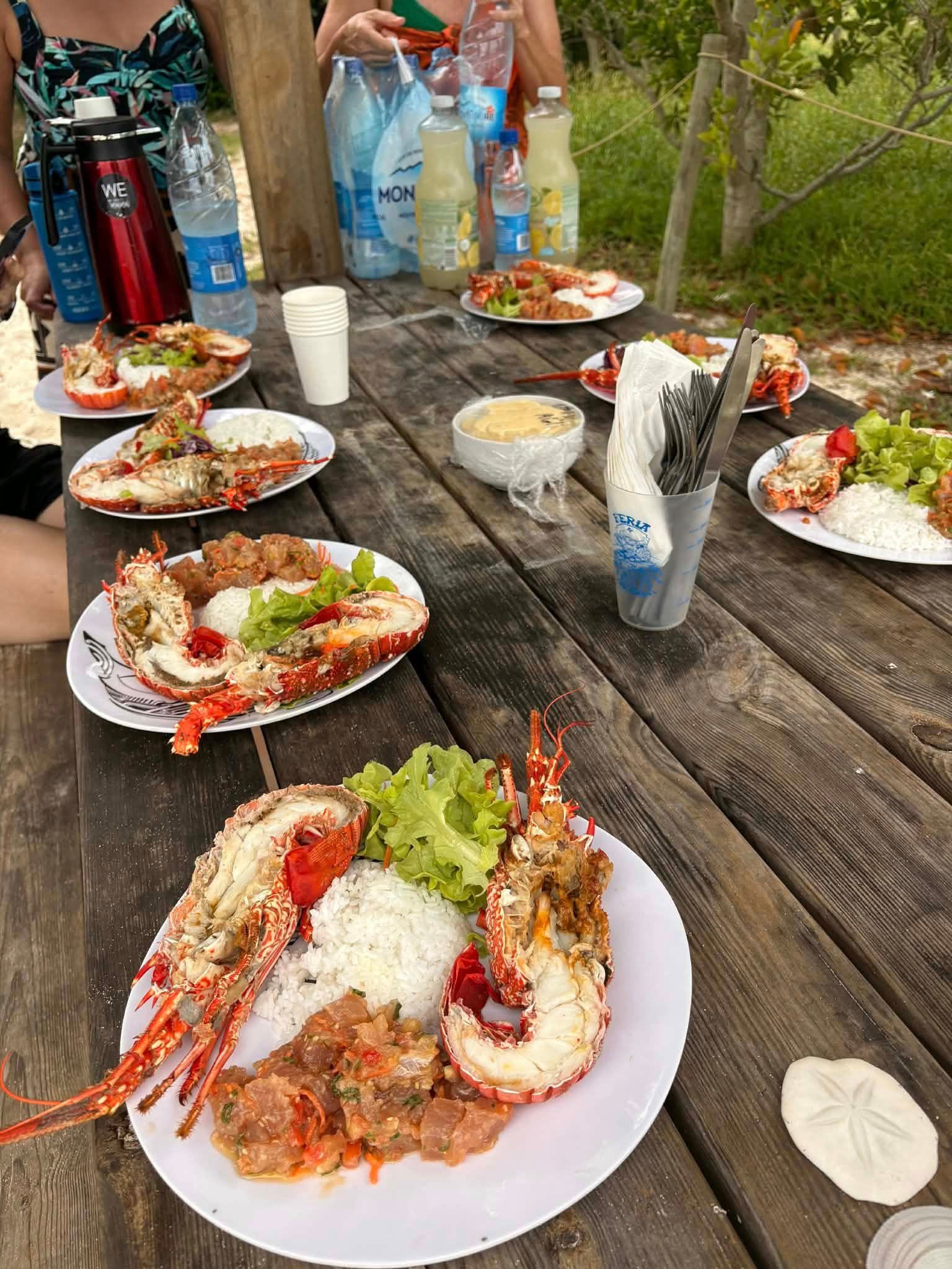 Tablée de langoustes et de riz dressée en bord de plage