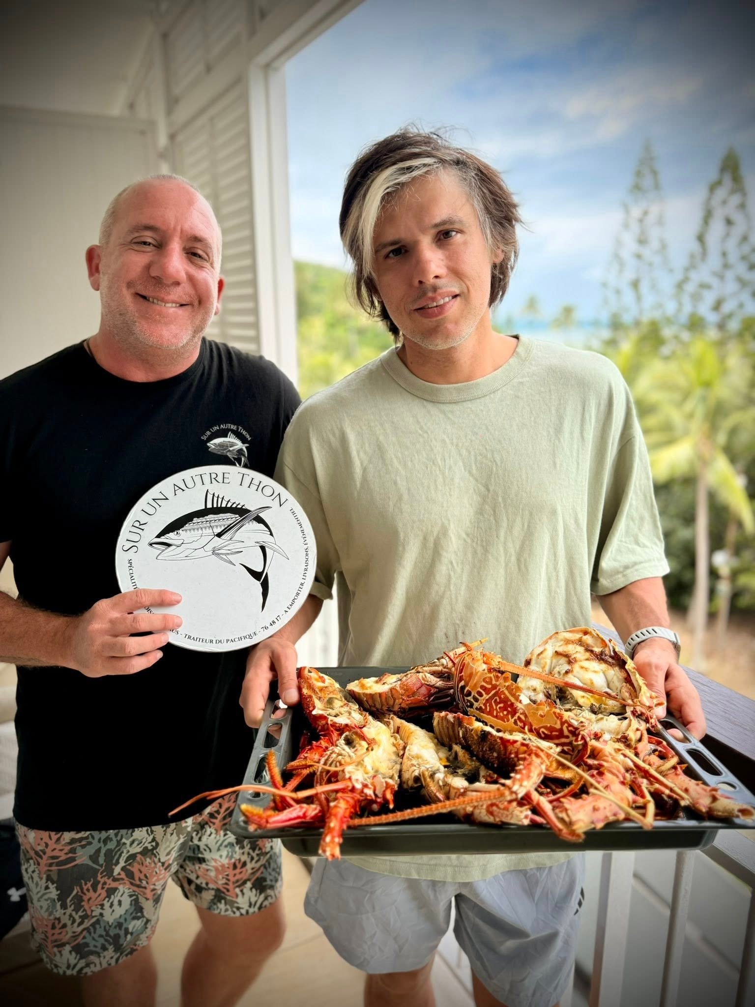 L'équipe présentant un plateau de langoustes grillées